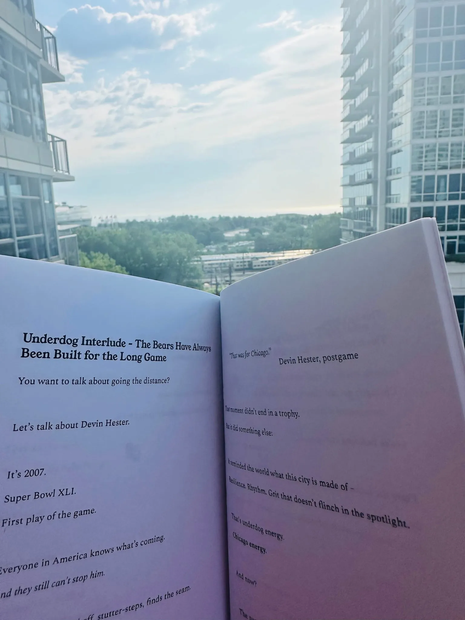 The book held open to the Underdog Interlude about the Bears, against a window overlooking downtown buildings